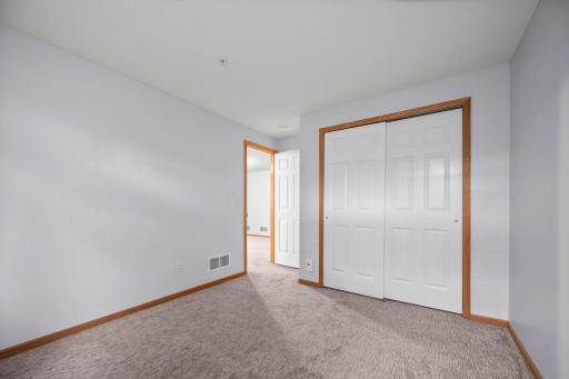 The lower-level bedroom includes a large closet with double sliding doors and plenty of space for furniture.
