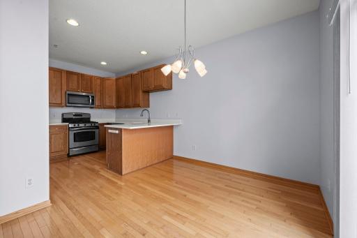 Functional kitchen and dining space combo featuring ample oak cabinetry and clean, white countertops.