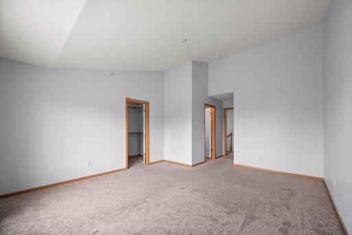 This bedroom view highlights the private nature of the upper level, complete with ample closet space and vaulted architectural details.