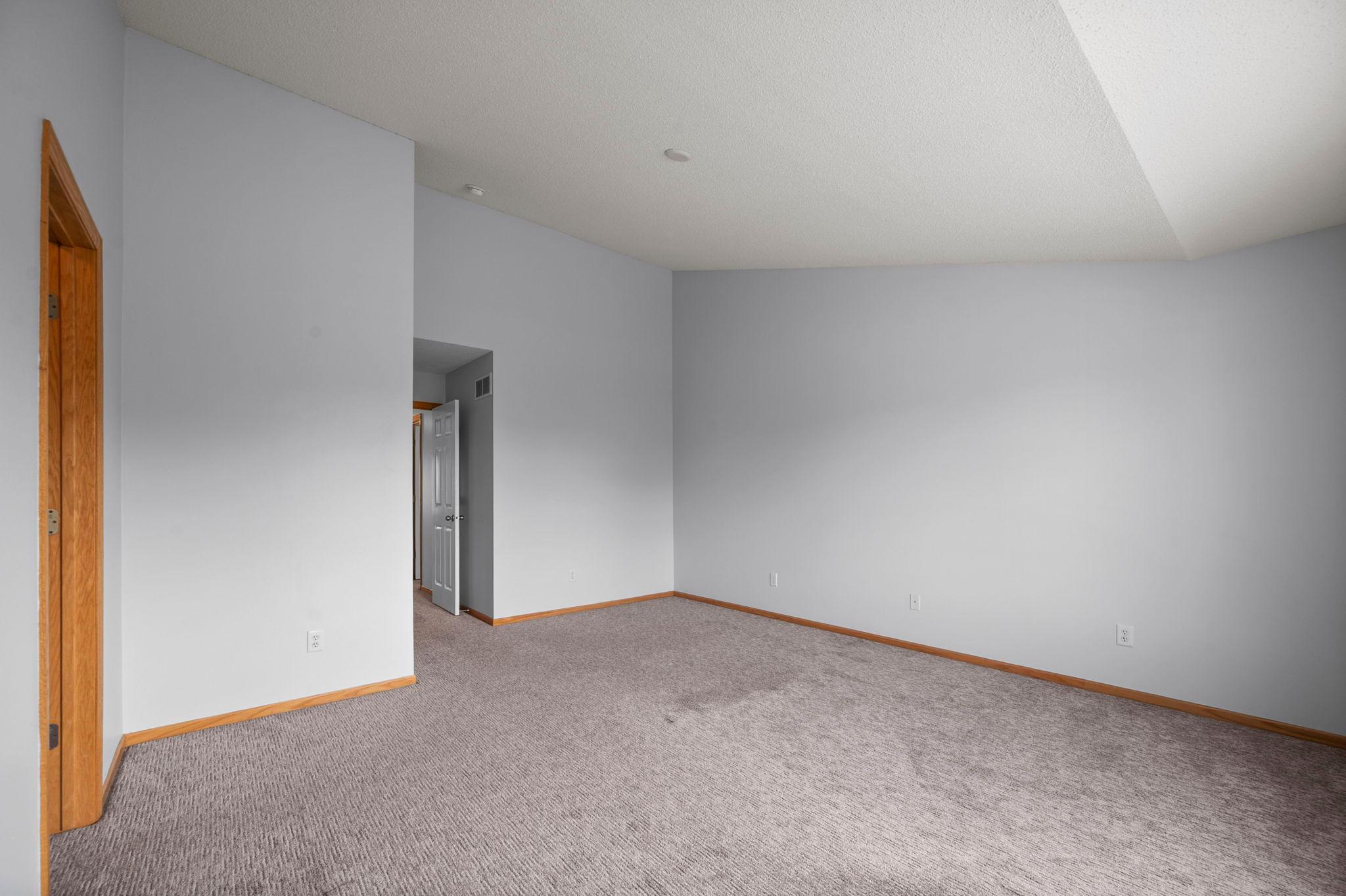 This expansive upper-level bedroom offers flexibility for various furniture layouts and is filled with natural light.