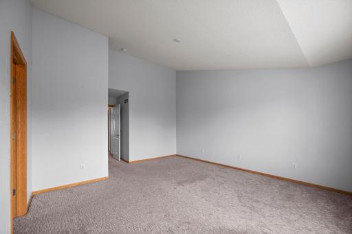 This expansive upper-level bedroom offers flexibility for various furniture layouts and is filled with natural light.