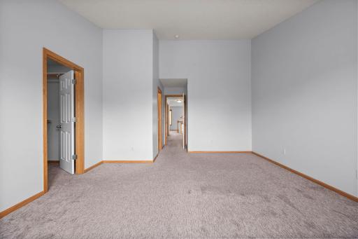 The primary bedroom is a spacious retreat featuring neutral tones, vaulted ceilings, and a large walk-in closet.