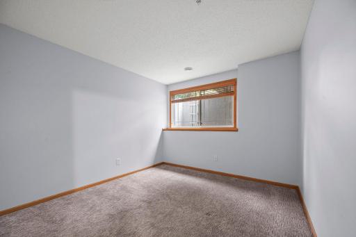 Comfortable lower-level bedroom featuring a large daylight window and neutral finishes.