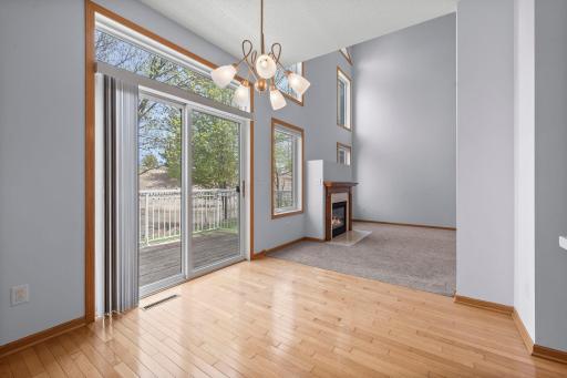 High-angle perspective showing the dining area's hardwood floors and its proximity to the light-filled living room.