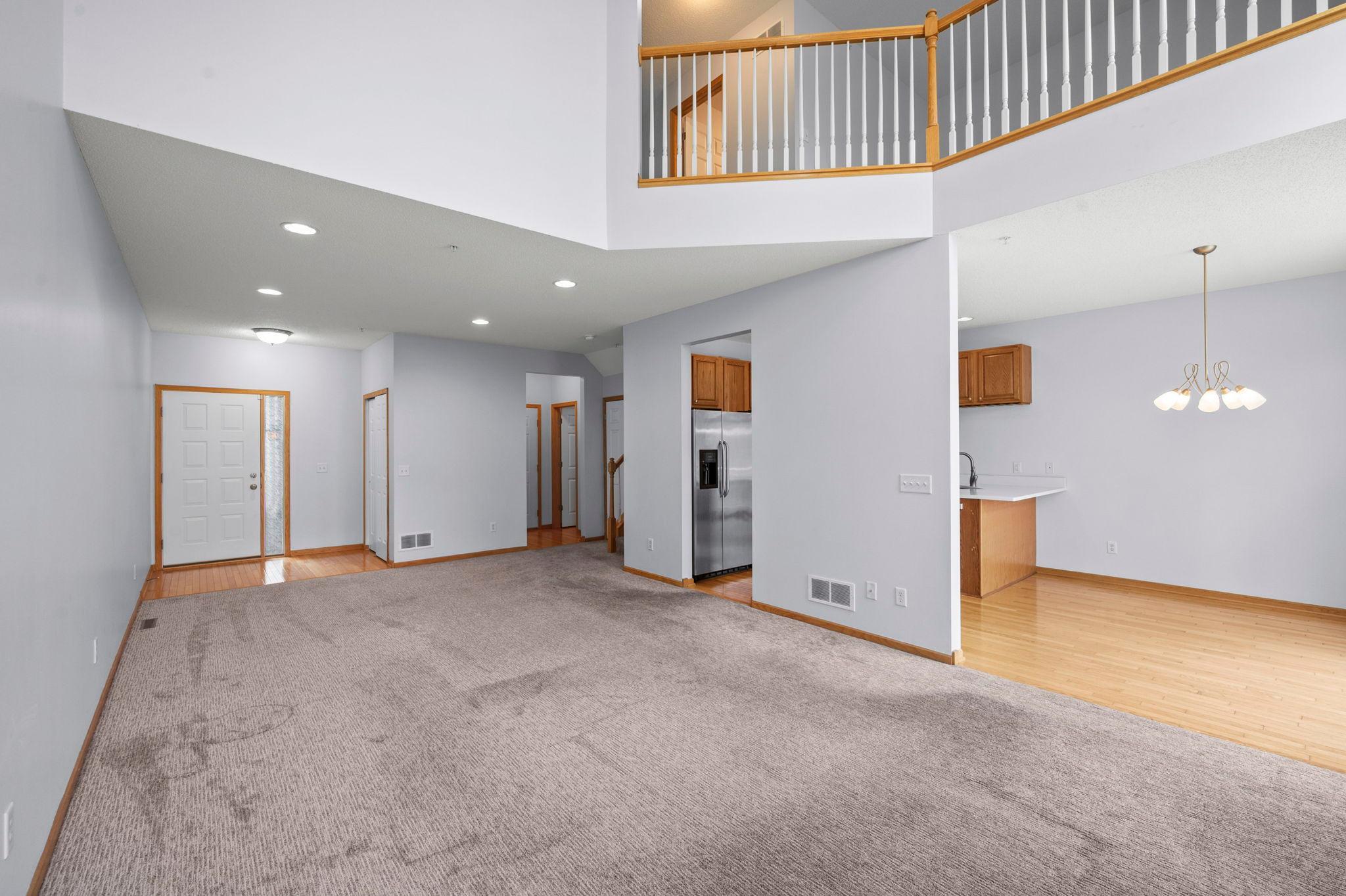 Expansive open-concept layout showing the seamless transition between the living area, kitchen, and upper-level loft.