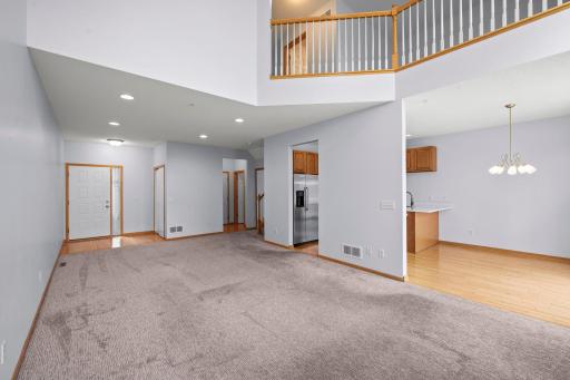 Expansive open-concept layout showing the seamless transition between the living area, kitchen, and upper-level loft.