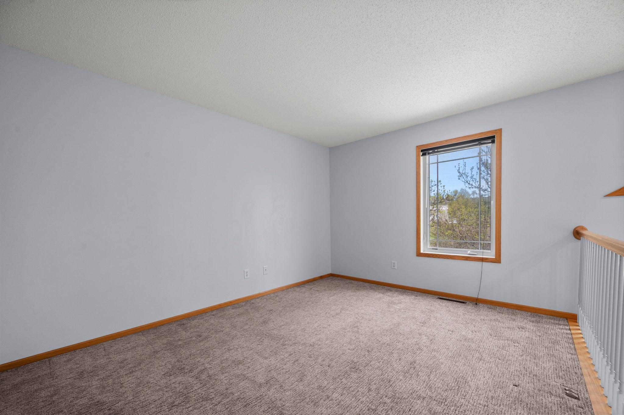 A spacious upper-level landing offers plenty of room for a secondary sitting area or a quiet reading nook.