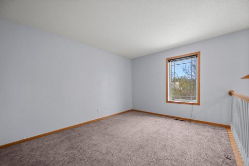 A spacious upper-level landing offers plenty of room for a secondary sitting area or a quiet reading nook.