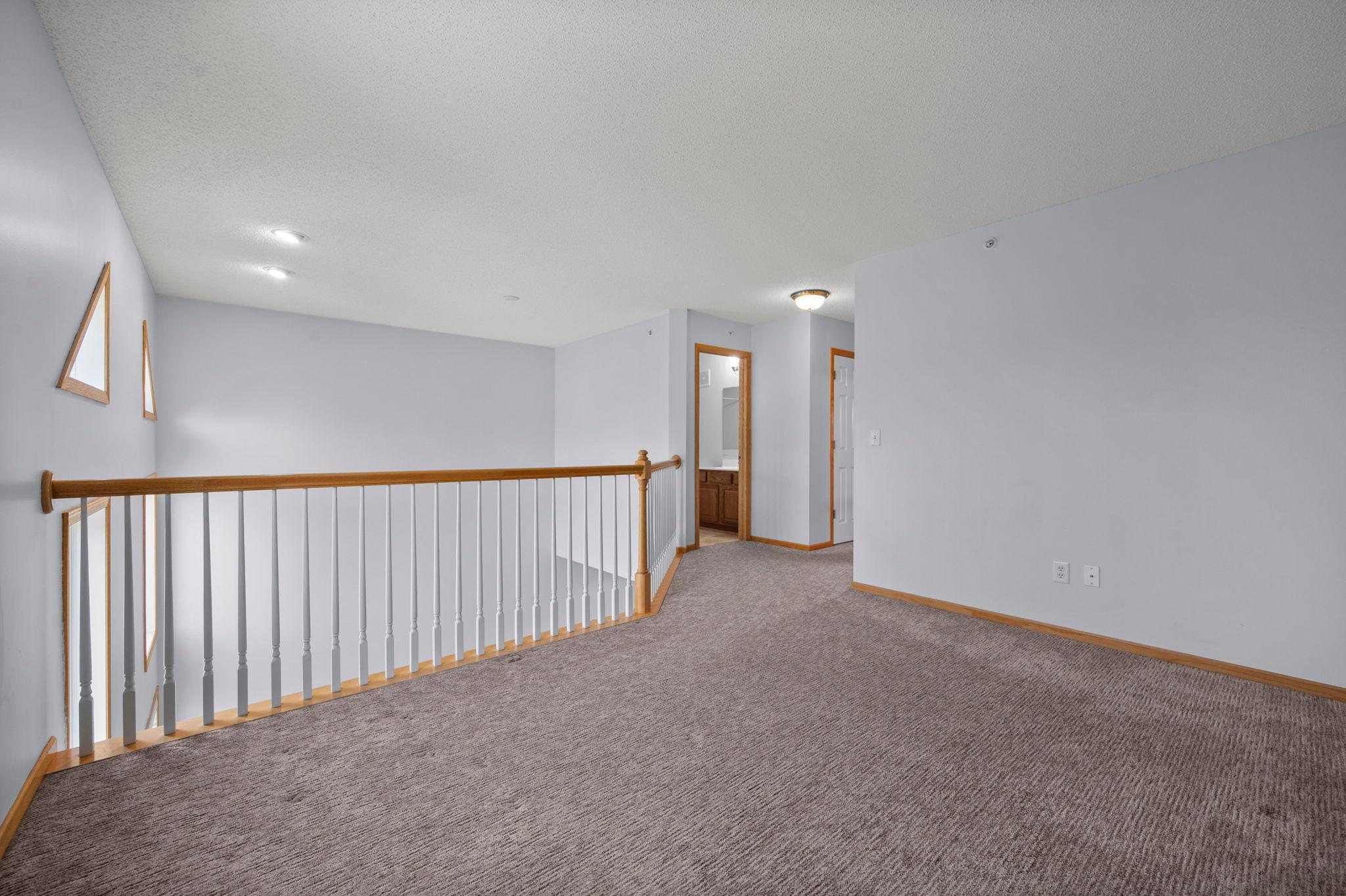 View from the loft area looking toward the upper-level bedrooms and the shared hallway bath.