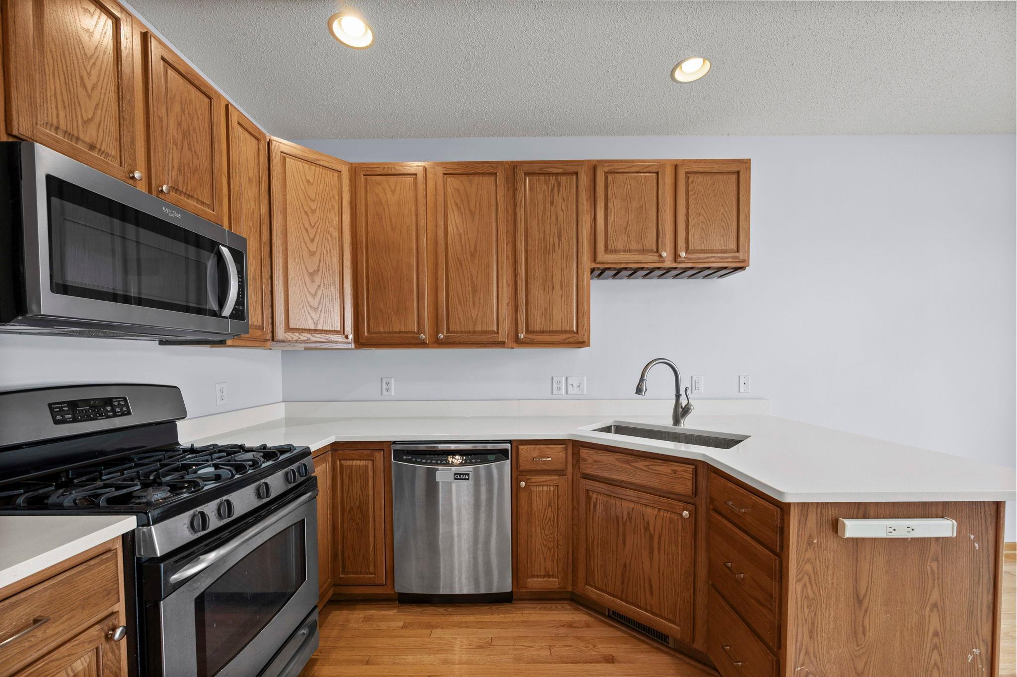 The kitchen's efficient U-shaped design provides easy access to the dishwasher and plenty of storage options.
