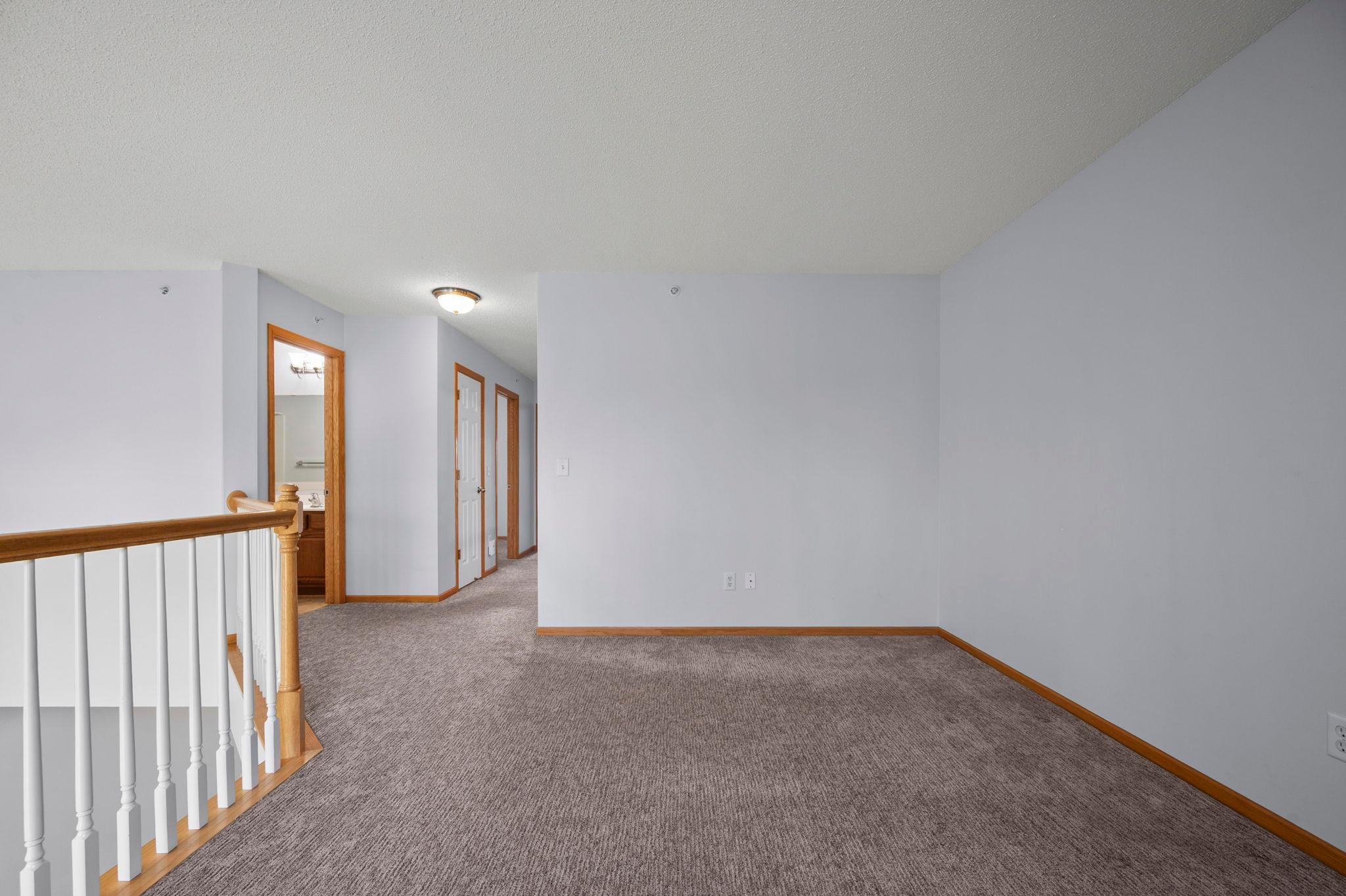 This wide-angle shot of the loft emphasizes the generous square footage available for a home office or media space.