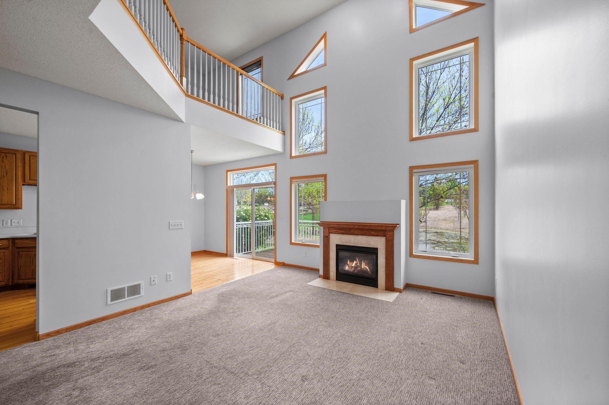 Bright and airy living space offering scenic views of the surrounding landscape and access to the outdoor deck.