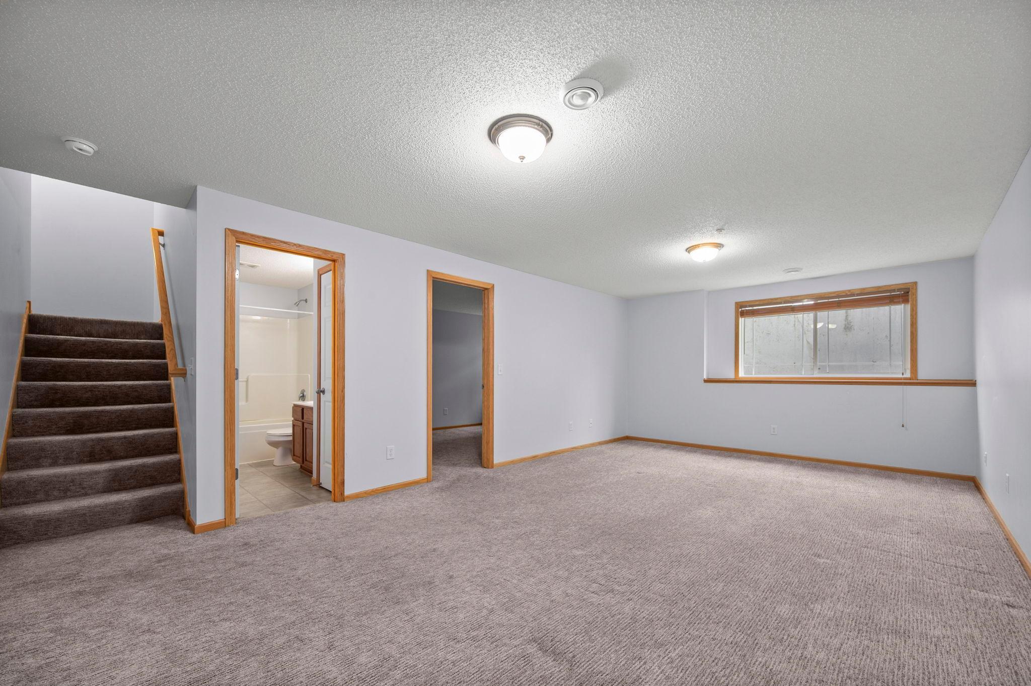 The finished basement family room features high ceilings and provides easy access to the lower-level bedrooms and bath.