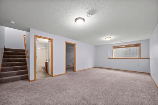The finished basement family room features high ceilings and provides easy access to the lower-level bedrooms and bath.