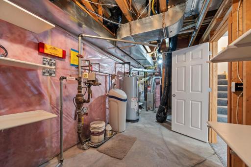 This utility area houses the homeâs mechanical systems, including a water softener and water heater.