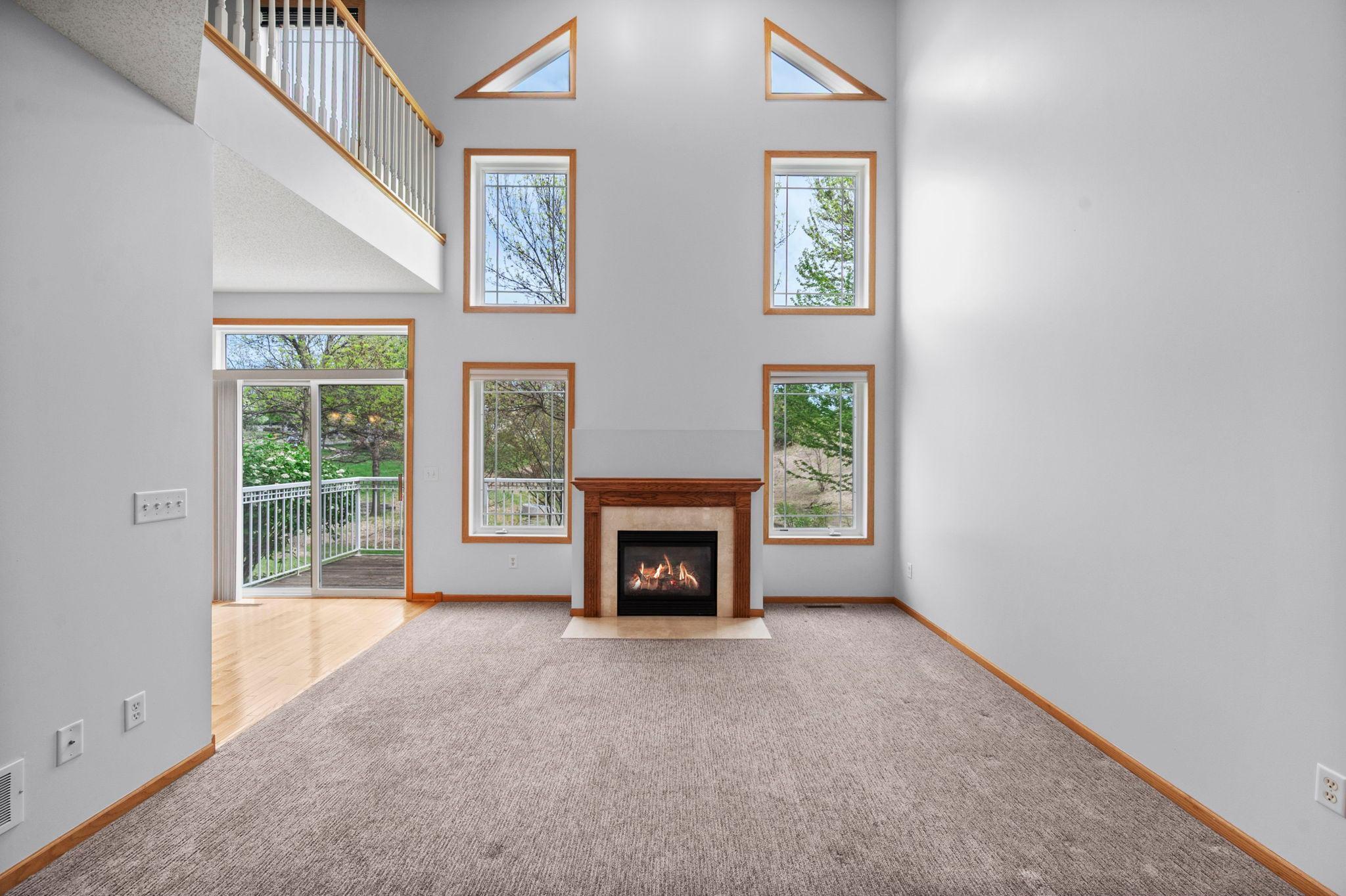 Impressive great room with a floor-to-ceiling window wall and view of the upper-level loft.