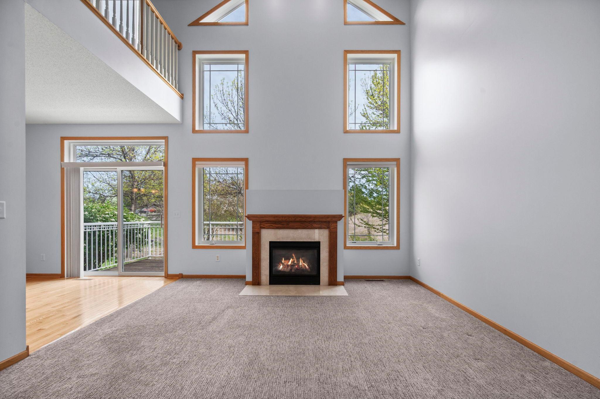 Dramatic floor-to-ceiling windows flank the cozy gas fireplace, flooding the great room with natural light.