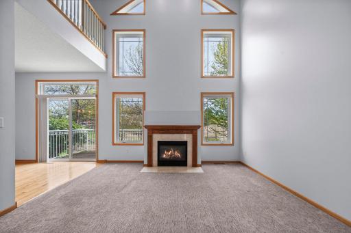 Dramatic floor-to-ceiling windows flank the cozy gas fireplace, flooding the great room with natural light.