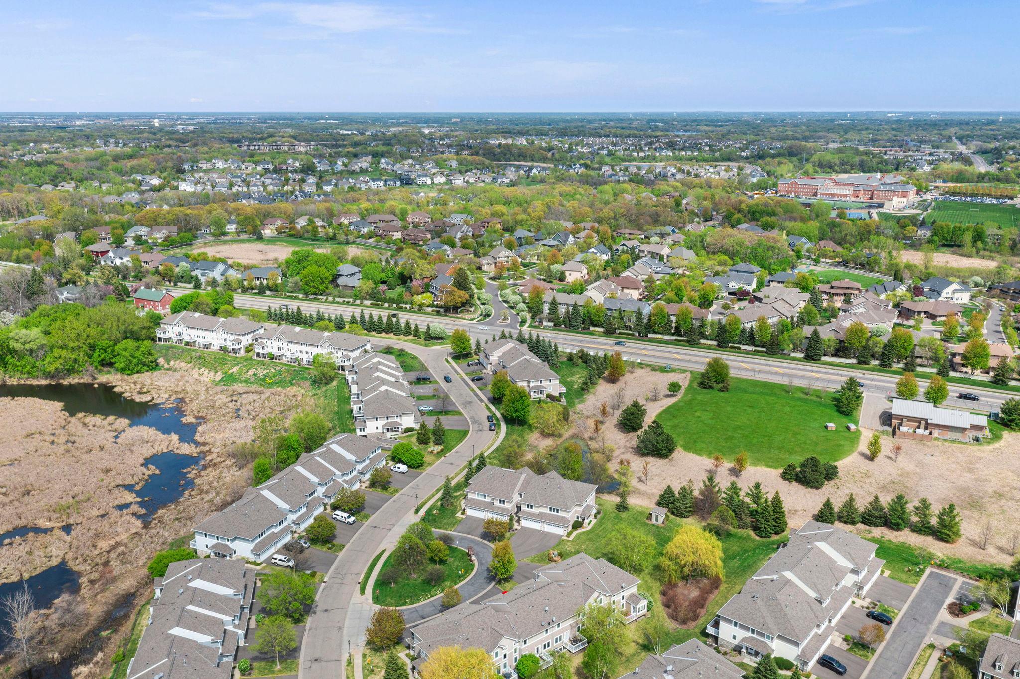 High-angle shot highlighting the quiet residential neighborhood and manicured community landscaping.