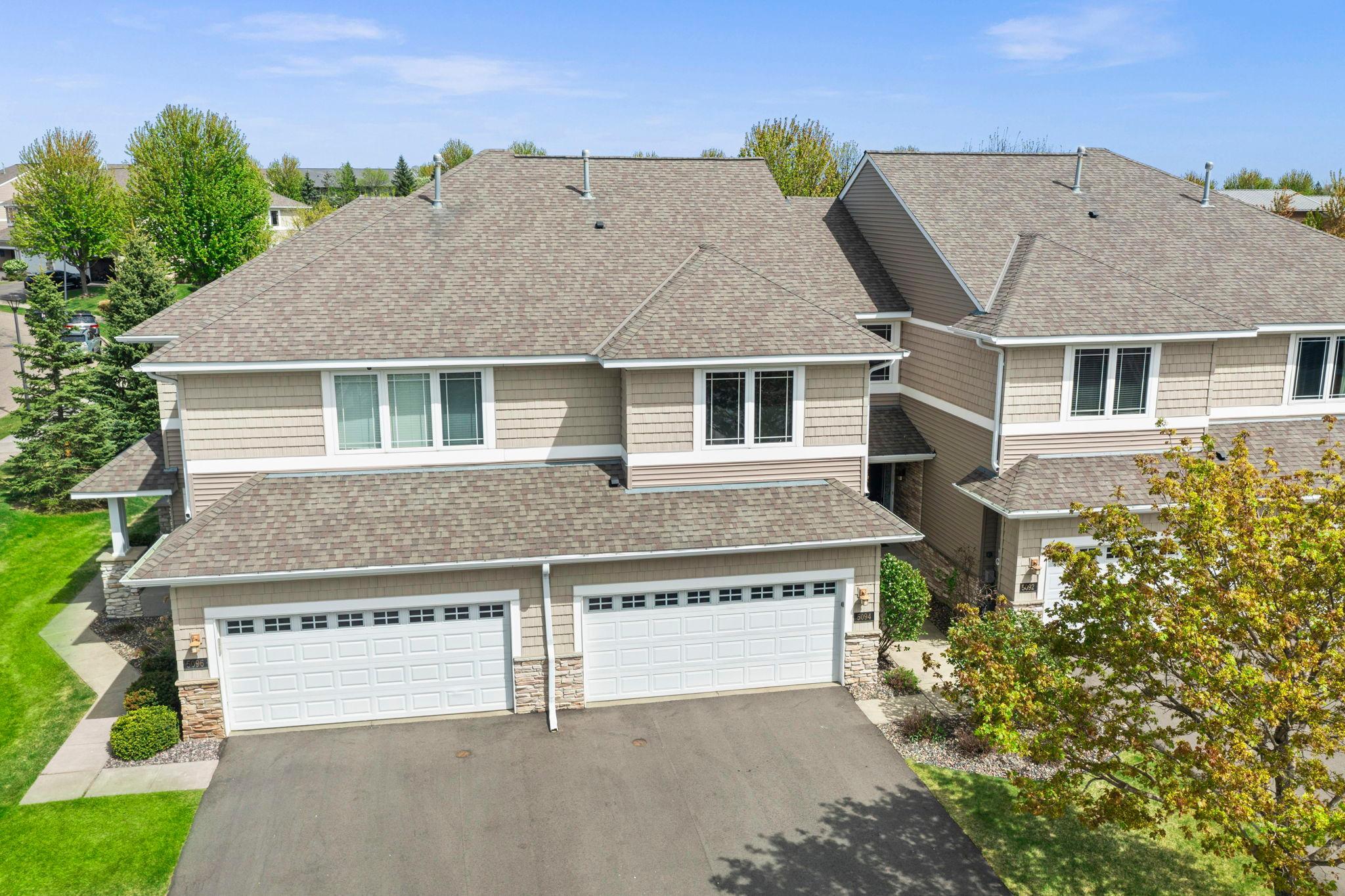 Front elevation view highlighting the modern siding, shake accents, and multiple two-car garages.