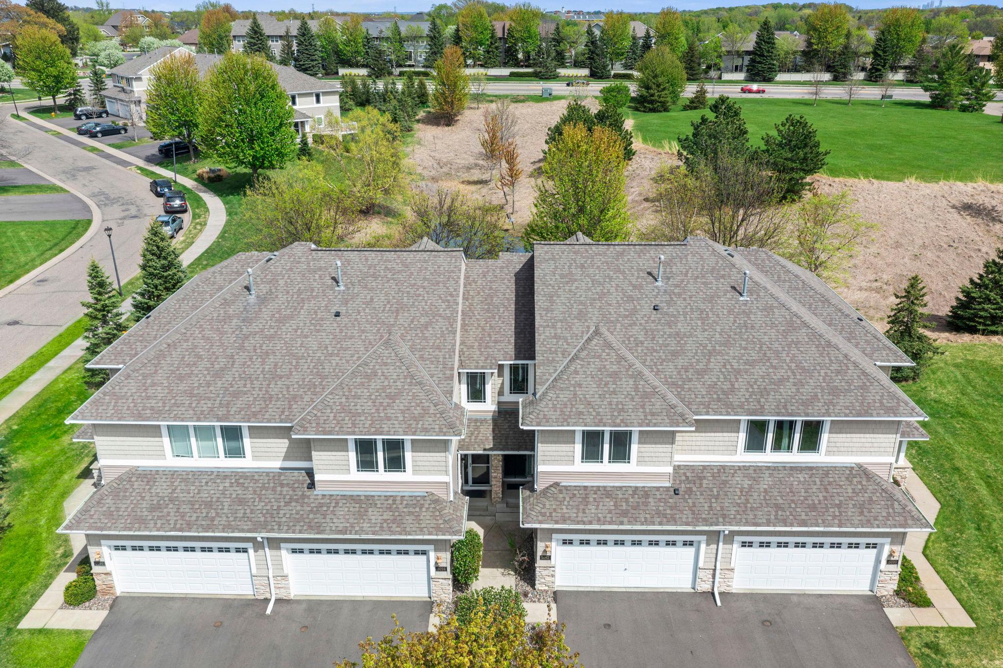 Top-down view of the rooflines and surrounding mature trees, emphasizing a private neighborhood feel.