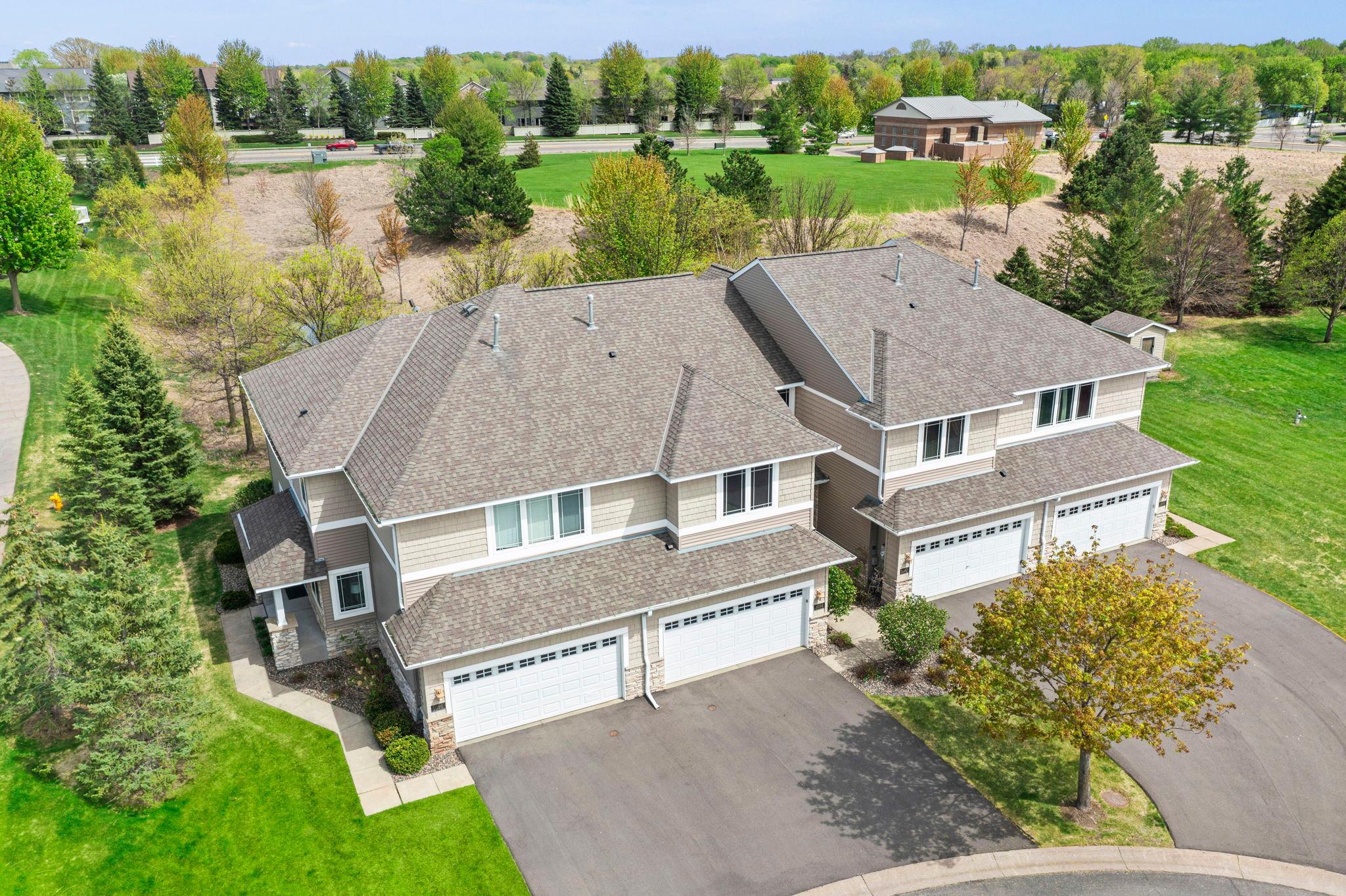 Bright and clear daytime exterior view highlighting the home's curb appeal, stone accents, and clean driveway.
