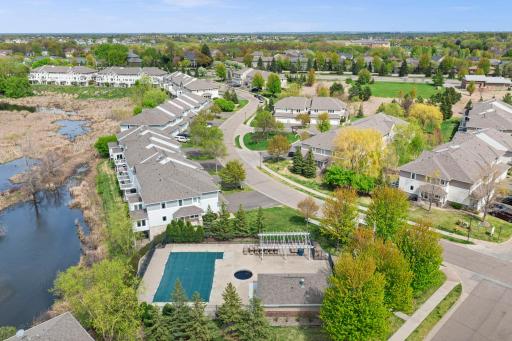 An aerial view of the community highlights the shared pool facility and its scenic location adjacent to the neighborhood pond.