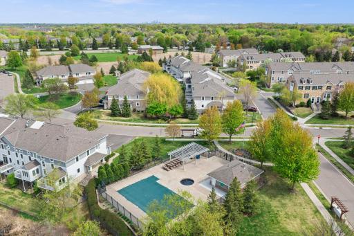 The private community pool is surrounded by lush green spaces and mature trees, offering a perfect summer retreat for residents.