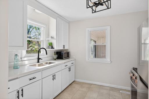 Modern white kitchen with Quartz countertops and SS appliances.