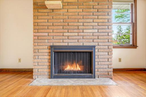 The brick wood burning fireplace anchors the space.