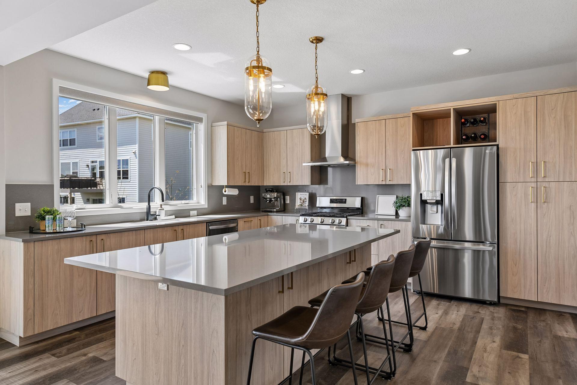 A stunning chef's kitchen with a large center island, walk-in pantry, on-trend fixtures and finishes, warm cabinetry, and smart everyday function.