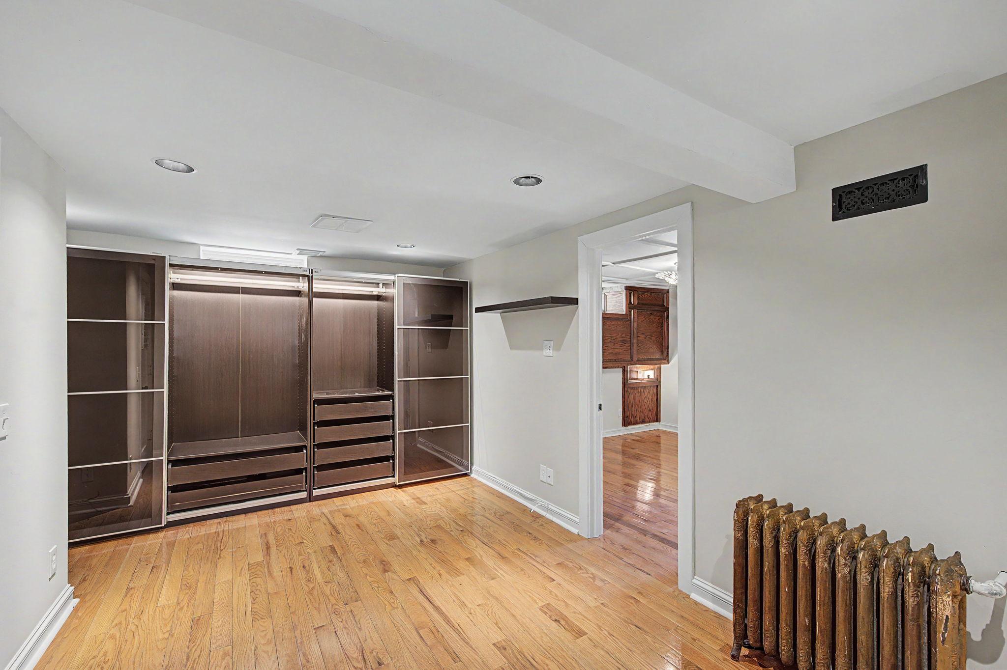 Spacious closet with built ins line the back wall.