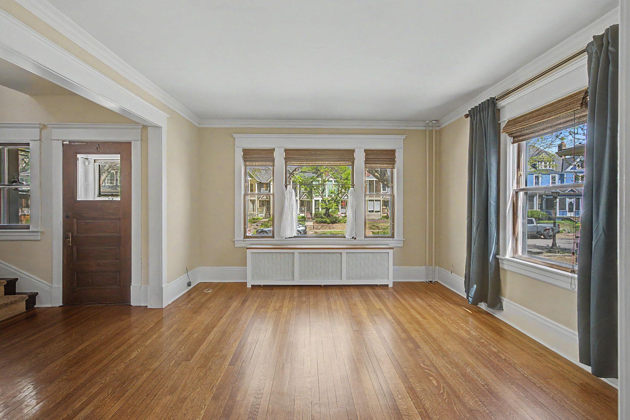Enter through the front door into the living room featuring wood floors and large windows streaming in plenty of natural light.