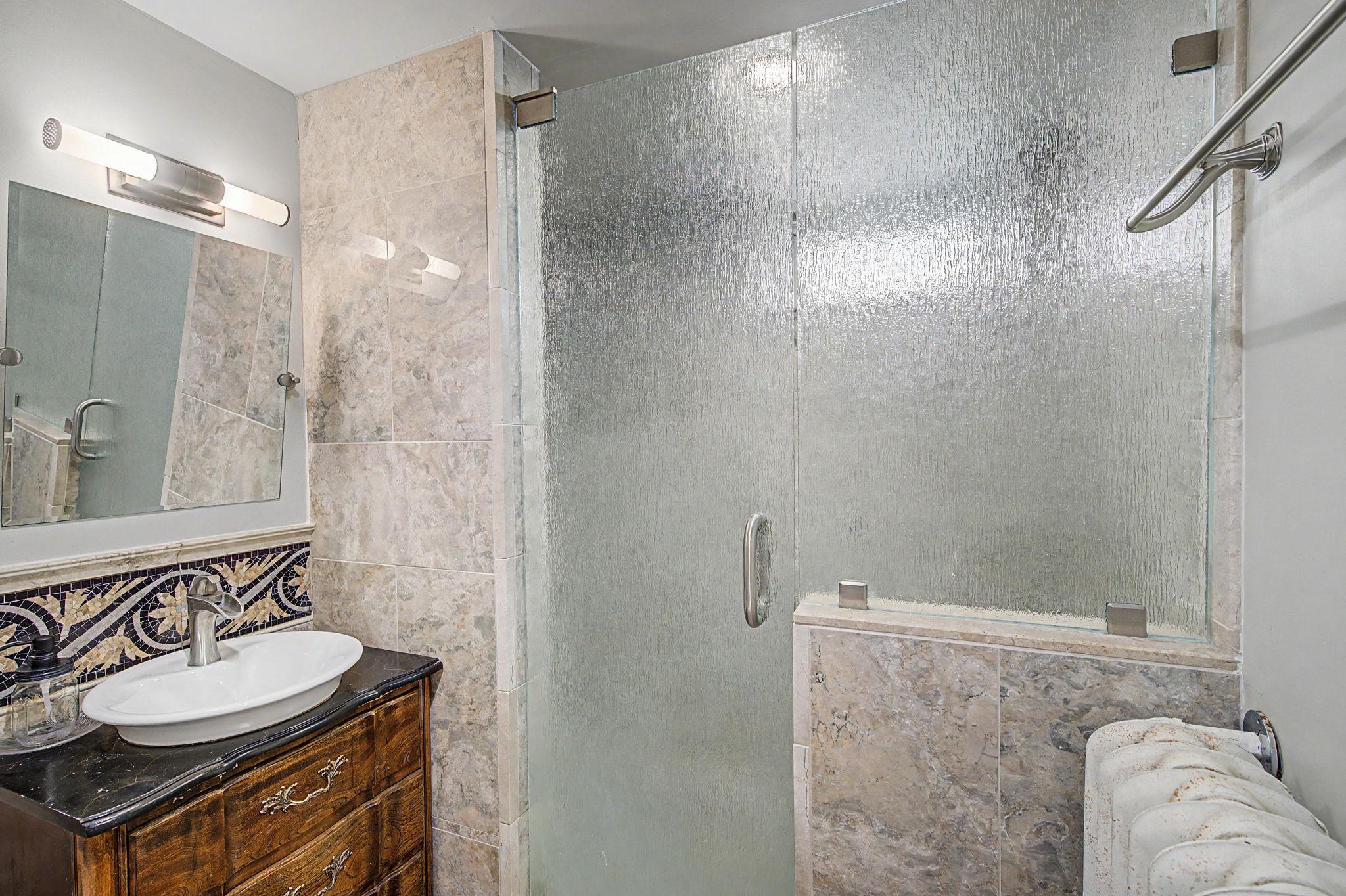 The lower level private bathroom features a spacious, tiled walk-in shower.