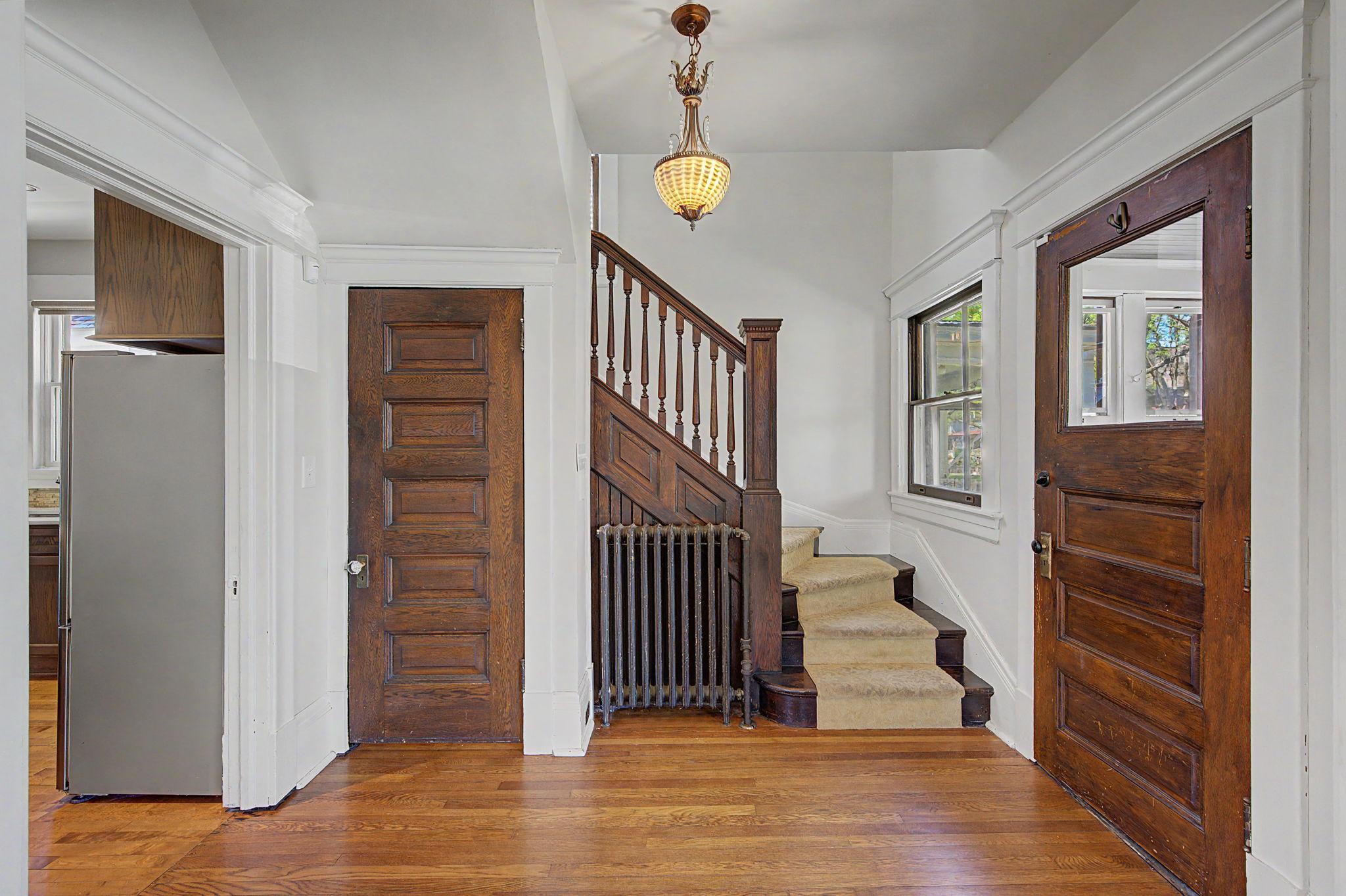 Foyer area inside the front door has the stairway going upstairs and the door on the left leads to the stairway to the lower level primary retreat area.