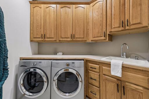 Main level laundry with newer washer/dryer, counter space for folding along, utility sink and more custom cabinetry for storage and everyday use. Home does have central vac with attachments.
