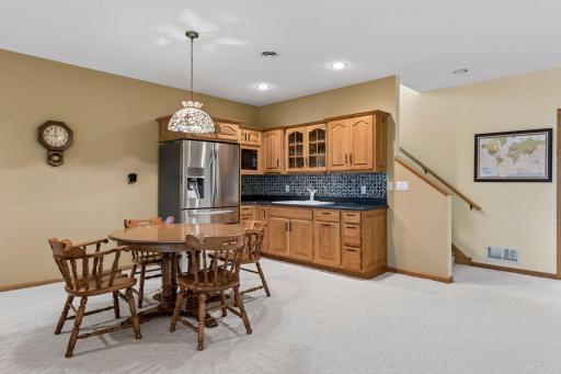 Bar area with Cambria counter tops, tile backsplash, microwave and deluxe premium refrigerator