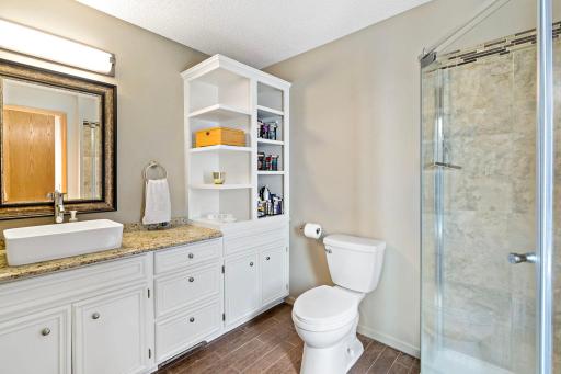 Private en suite primary bath with tiled floors, tiled shower and lots of storage