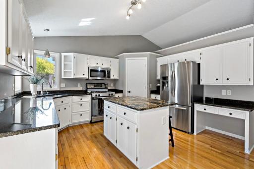 The open and white kitchen features stainless steel appliances, a bosch dishwasher and reverse osmosis water filtration system.