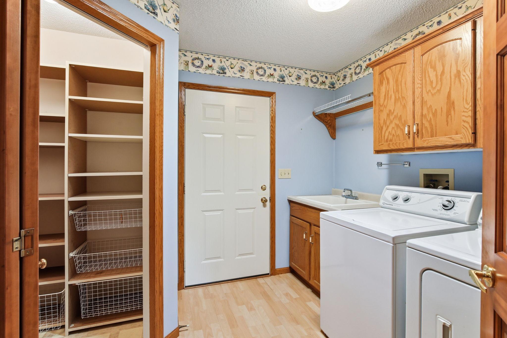 Large Laundry room off the garage with cabinets and sink.
