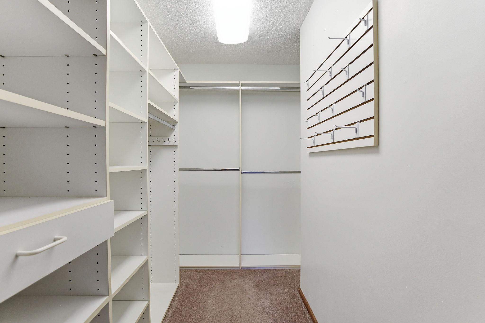 Custom Closet Organization in the Primary Walk-In Closet.