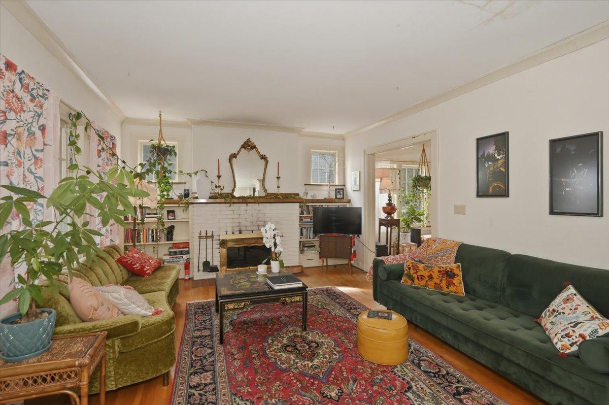 Living room with wood-burning fireplace. built-ins, crown molding and hardwood floors.