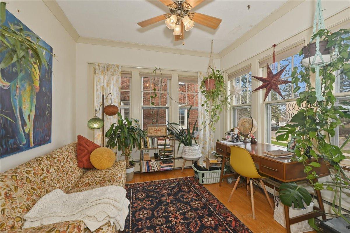 Sunroom with crown molding and hardwood floors.