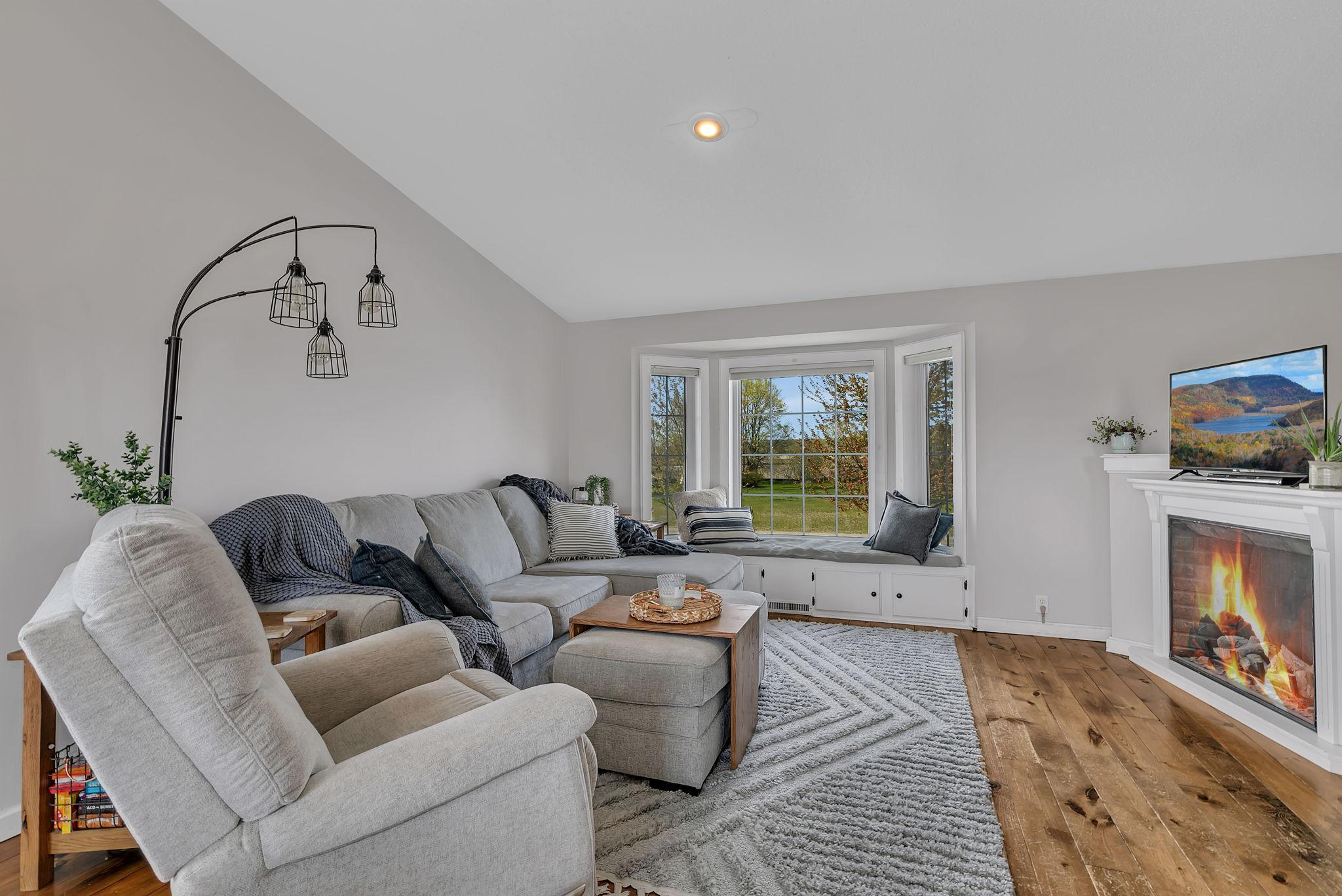 Wood floors, electric fireplace and vaulted ceiling create a warm and airy feel on the upper level