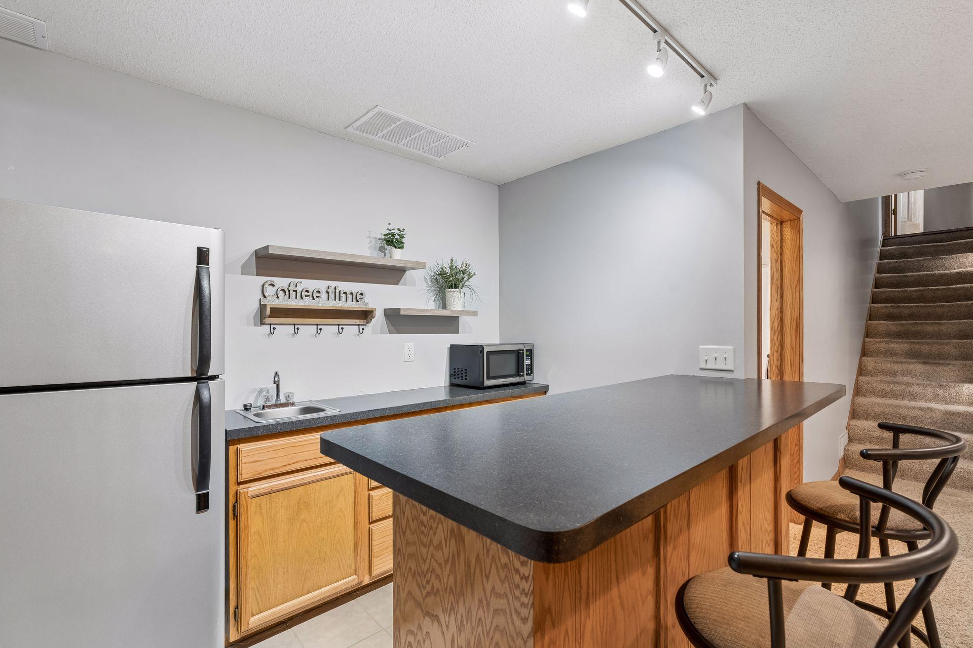 Lower level wet bar with seating area creates the perfect setup for entertaining or hosting guests.
