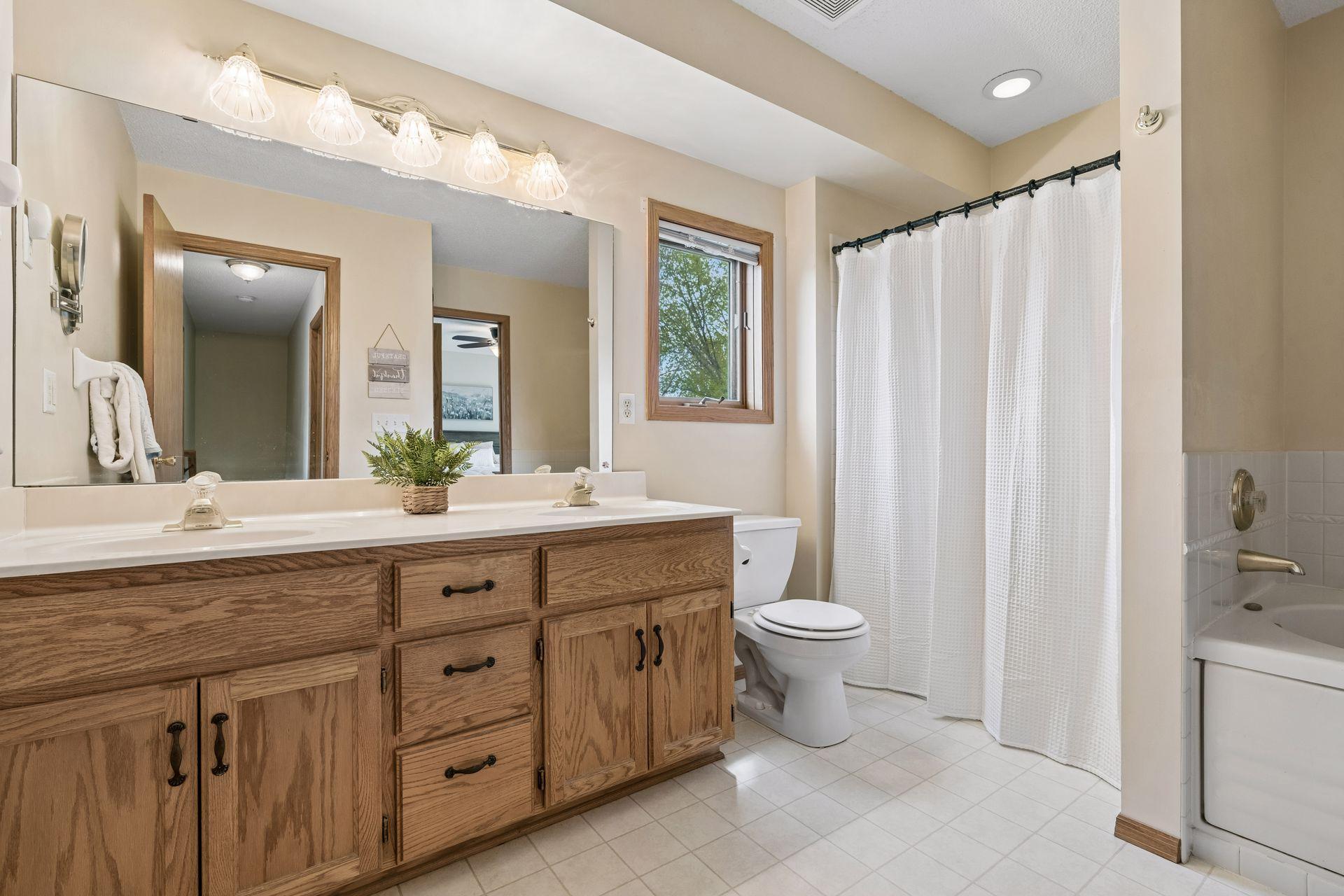 Large upper level walk-through bath with oversized vanity, abundant storage, and natural light.