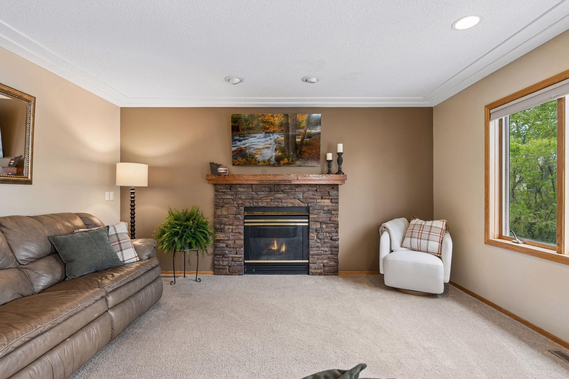 Cozy family room featuring a gas-burning fireplace, large window, and comfortable space to relax or gather with guests.