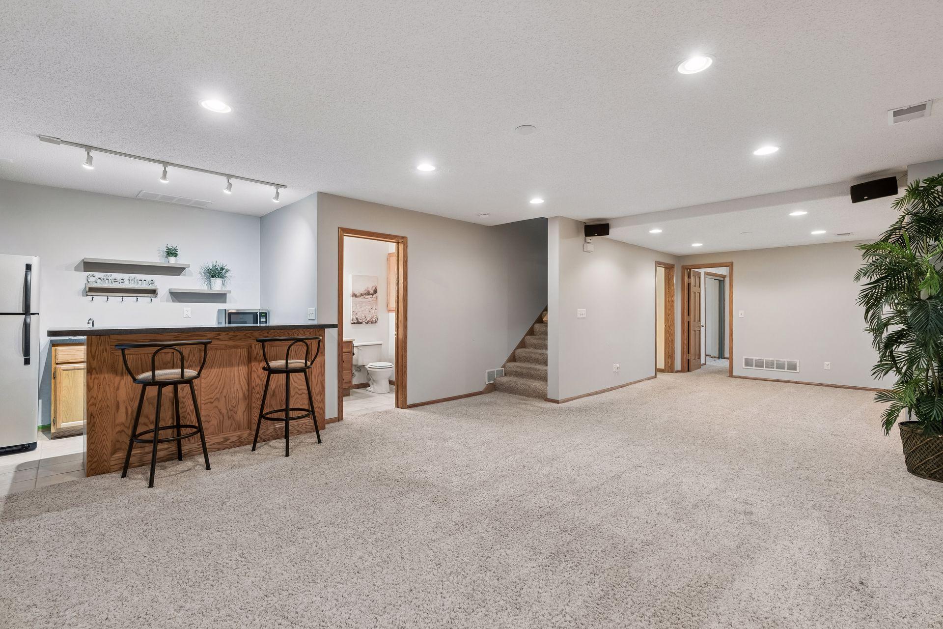 Expansive lower level family room with wet bar, recessed lighting, and plenty of flexible space for entertaining, games, or movie nights.