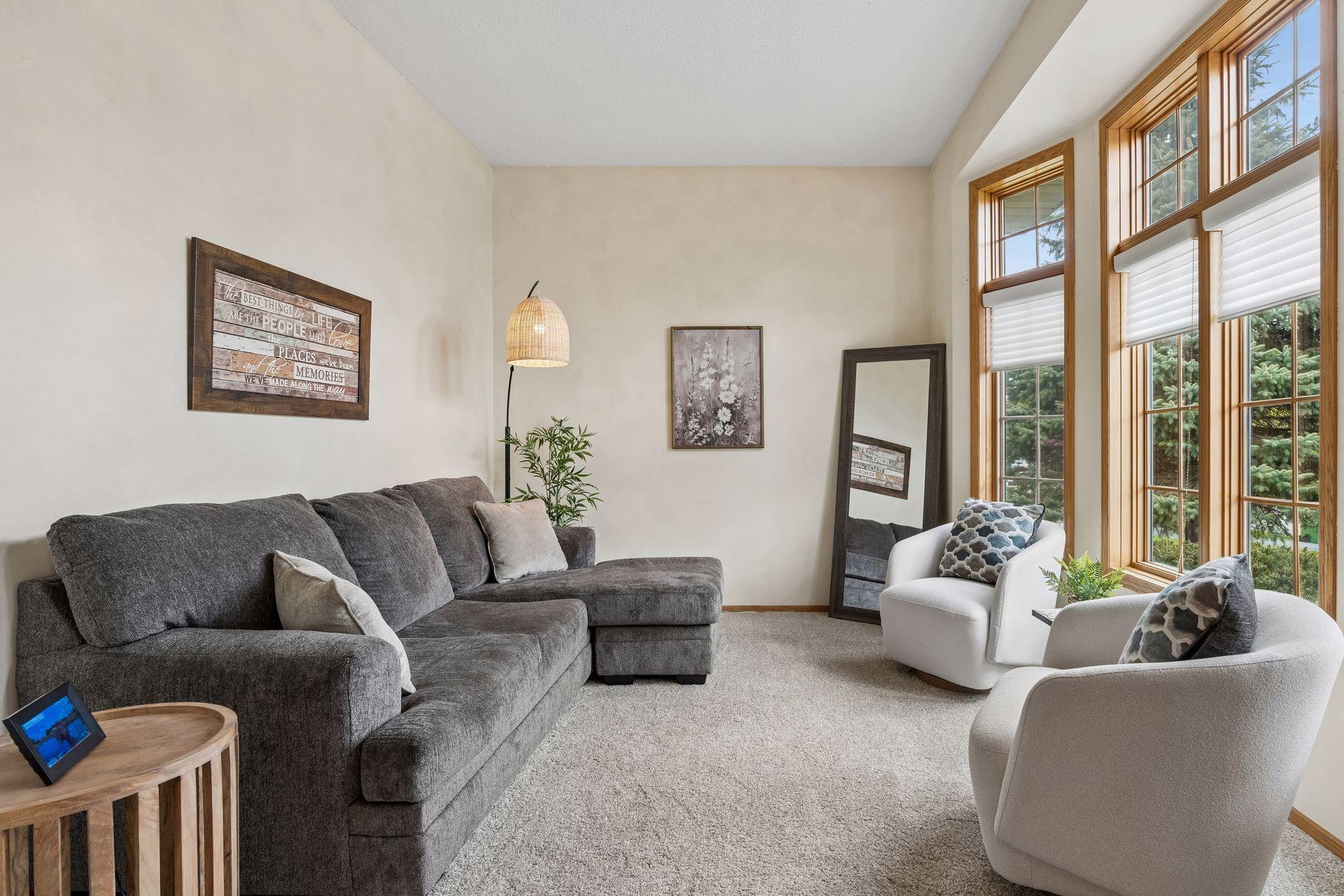 Living room features soaring ceilings, oversized windows, and abundant natural light creating an open and airy feel.