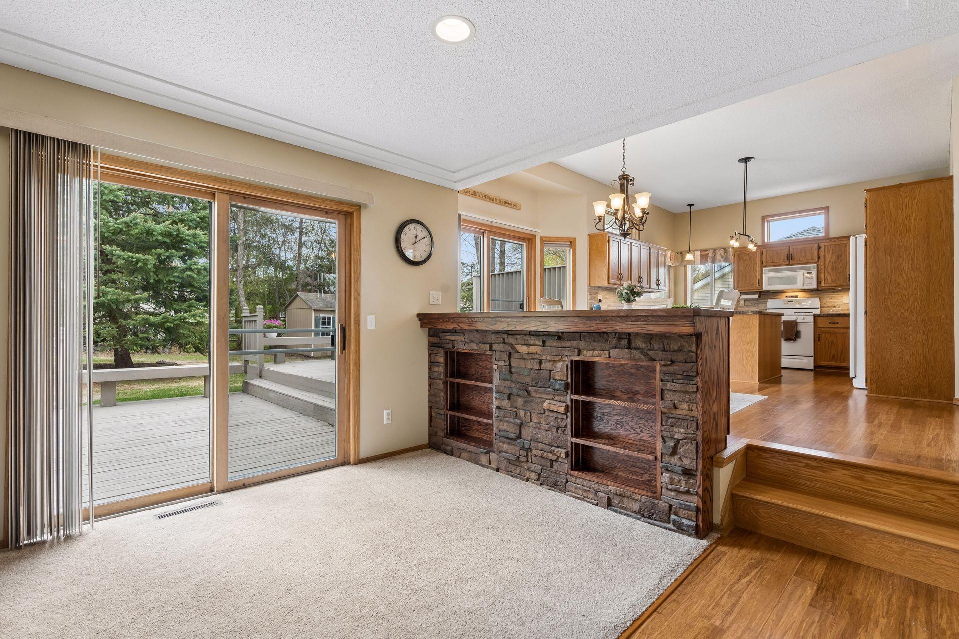 Custom built-in with stone accents adds character and storage, while the second deck access creates easy indoor-outdoor flow.